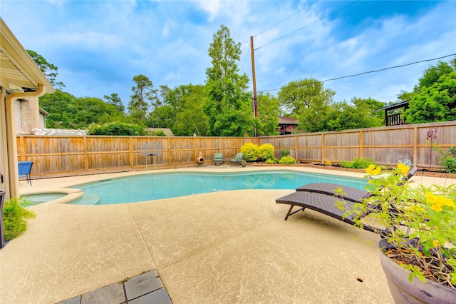 view of pool with a patio, a pool with connected hot tub, and a fenced backyard