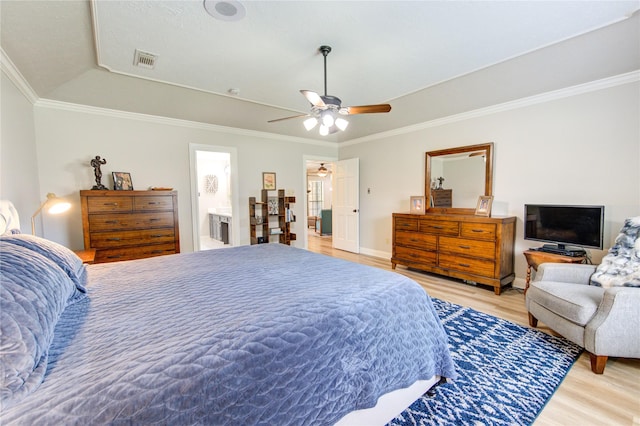 bedroom with light wood-style floors, a raised ceiling, ornamental molding, and visible vents