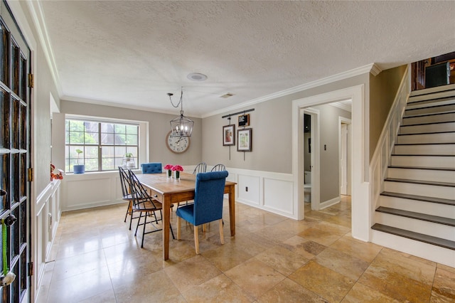 dining space with crown molding, a textured ceiling, stairway, and a decorative wall