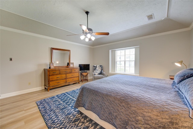 bedroom with visible vents, ornamental molding, wood finished floors, baseboards, and ceiling fan