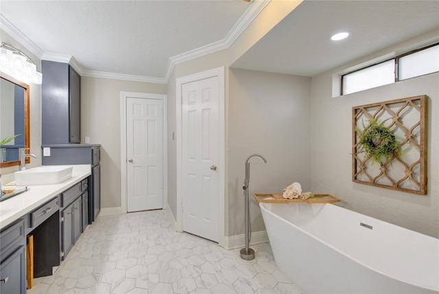bathroom featuring a freestanding tub, baseboards, ornamental molding, and vanity