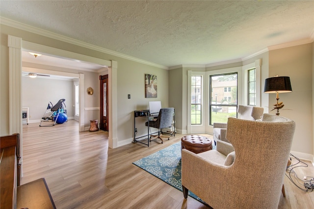 living room with baseboards, ornamental molding, and light wood-style flooring