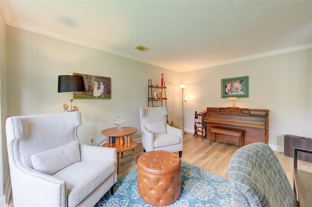 sitting room featuring baseboards, ornamental molding, wood finished floors, and visible vents