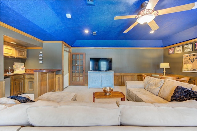 carpeted living area featuring a sink, ornamental molding, and a ceiling fan