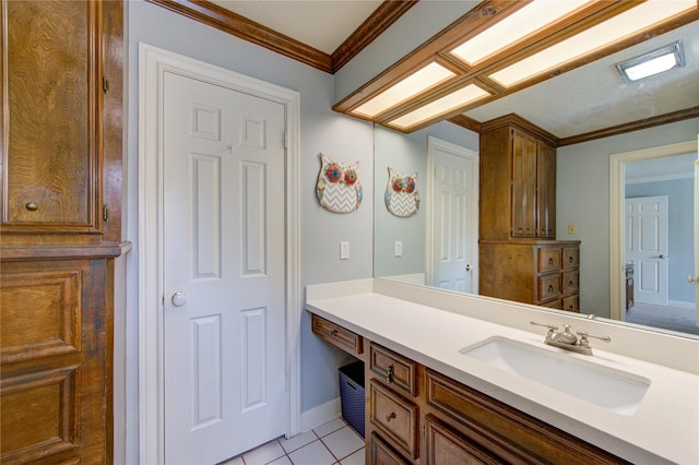 bathroom with vanity, baseboards, crown molding, and tile patterned flooring
