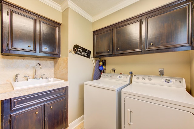 laundry area featuring a sink, separate washer and dryer, ornamental molding, and cabinet space