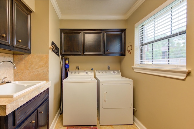 laundry room with cabinet space, separate washer and dryer, crown molding, and a sink