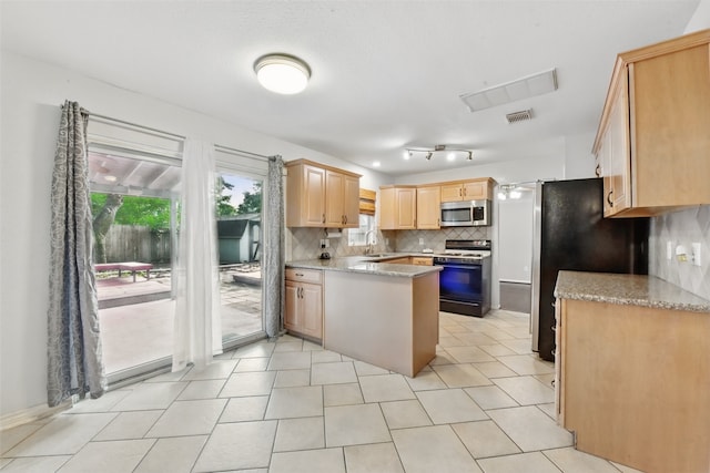 kitchen with light brown cabinetry, a sink, stainless steel appliances, backsplash, and visible vents