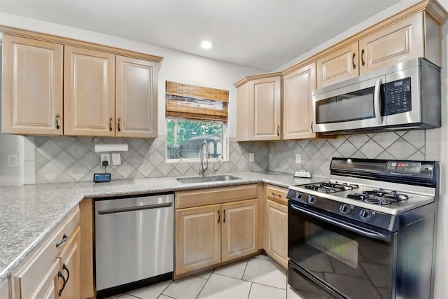 kitchen with light countertops, stainless steel appliances, a sink, and light brown cabinets