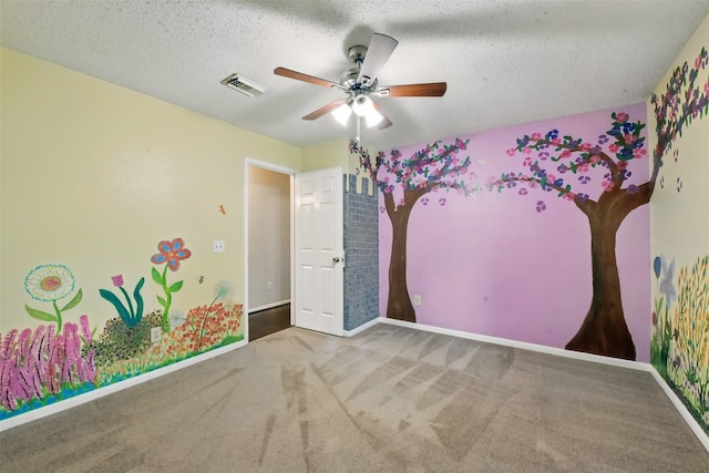 unfurnished room featuring ceiling fan, a textured ceiling, carpet, baseboards, and visible vents
