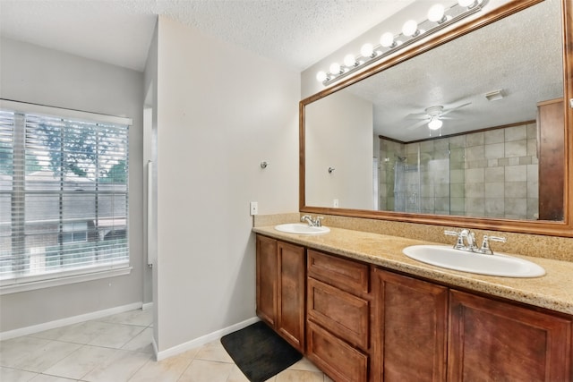 full bathroom featuring a sink, tile patterned flooring, tiled shower, and a wealth of natural light