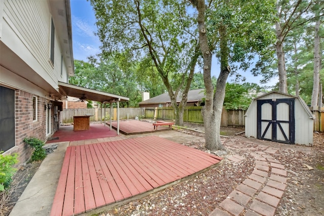 deck with ceiling fan, an outbuilding, a patio area, a fenced backyard, and a shed