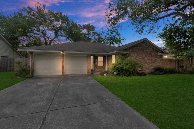single story home featuring brick siding, a garage, fence, and a yard