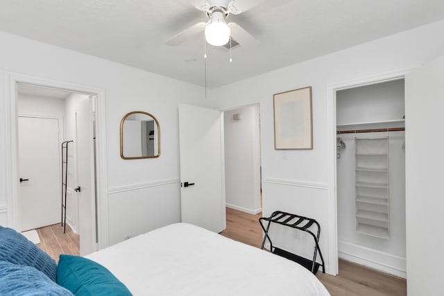 bedroom with ceiling fan, visible vents, light wood finished floors, and a closet