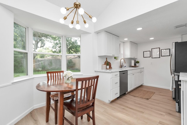 kitchen featuring white cabinets, a notable chandelier, appliances with stainless steel finishes, a sink, and visible vents