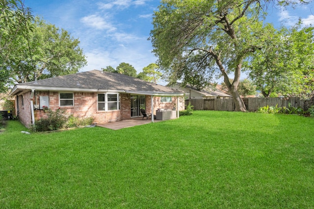 back of house featuring a fenced backyard, a patio area, and a yard