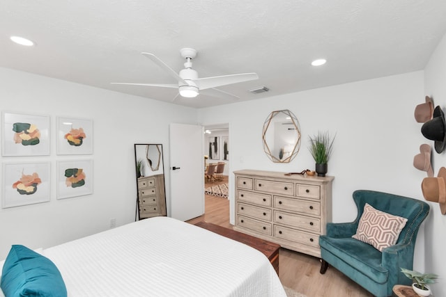 bedroom with a ceiling fan, recessed lighting, wood finished floors, and visible vents