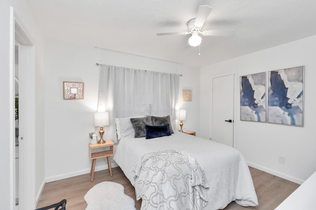 bedroom featuring baseboards, ceiling fan, and wood finished floors