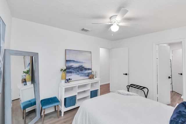 bedroom with visible vents, a ceiling fan, and light wood-style flooring