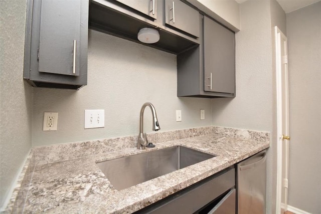 kitchen with a sink, gray cabinets, and stainless steel dishwasher