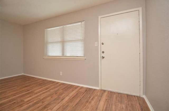 entrance foyer featuring baseboards and wood finished floors