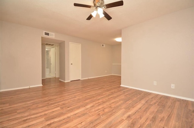 empty room featuring ceiling fan, visible vents, baseboards, and light wood-type flooring