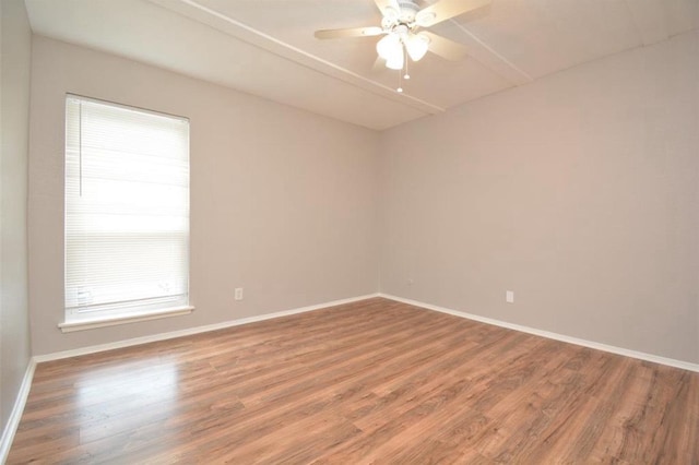 spare room featuring a ceiling fan, baseboards, and wood finished floors