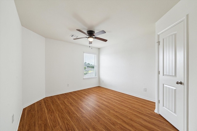 empty room featuring visible vents, baseboards, ceiling fan, and wood finished floors