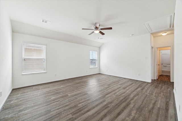unfurnished room with attic access, a ceiling fan, baseboards, wood finished floors, and visible vents