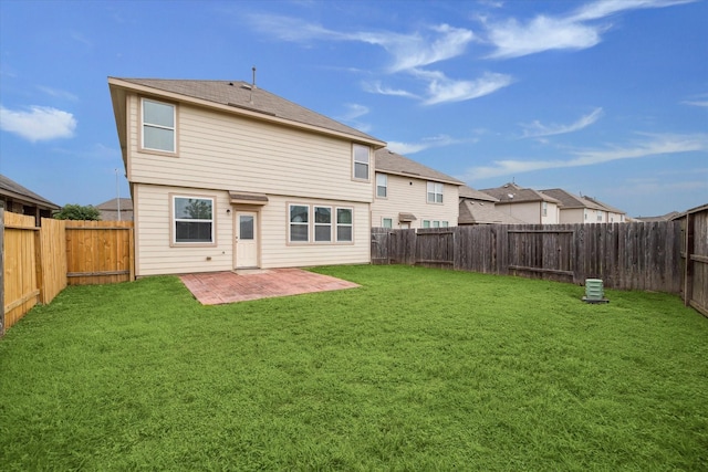 rear view of house featuring a fenced backyard, a patio area, and a yard