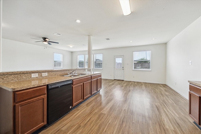 kitchen featuring a sink, a healthy amount of sunlight, light wood-style floors, and dishwasher