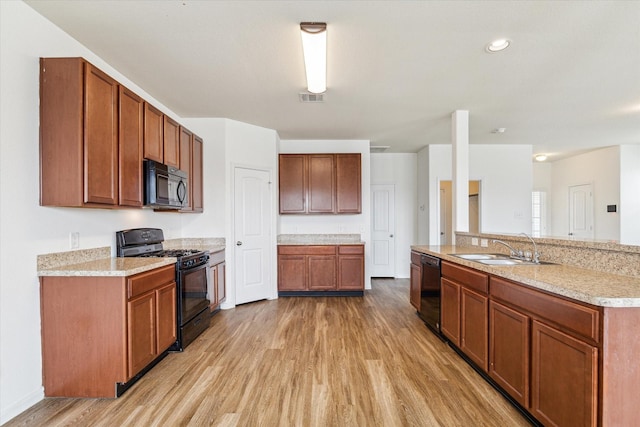 kitchen with visible vents, light countertops, light wood-style flooring, and black appliances