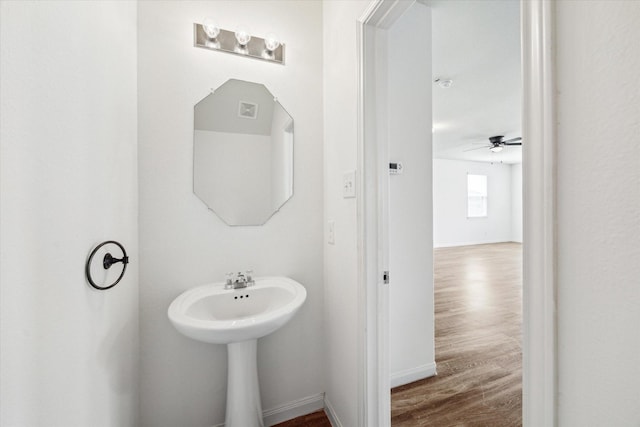 bathroom featuring a sink, baseboards, a ceiling fan, and wood finished floors