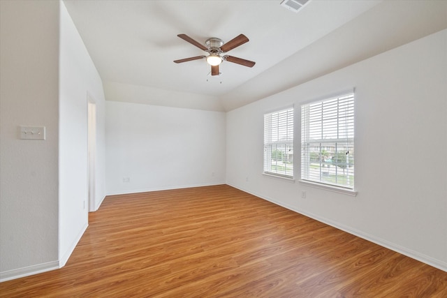empty room featuring light wood-type flooring, a ceiling fan, baseboards, and visible vents