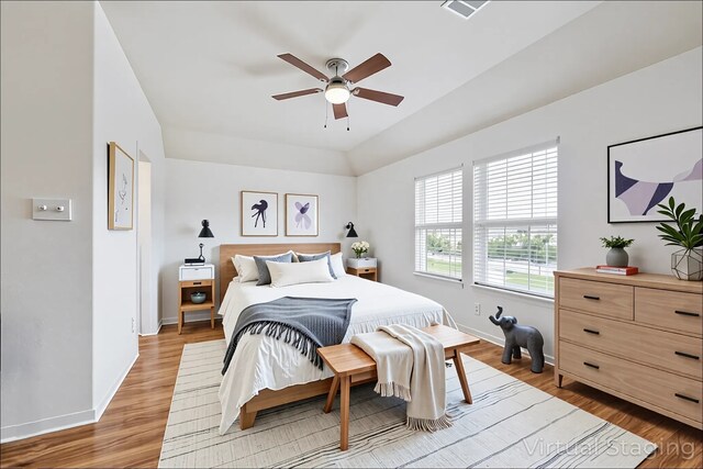 bedroom featuring light wood-style floors, baseboards, ceiling fan, and visible vents