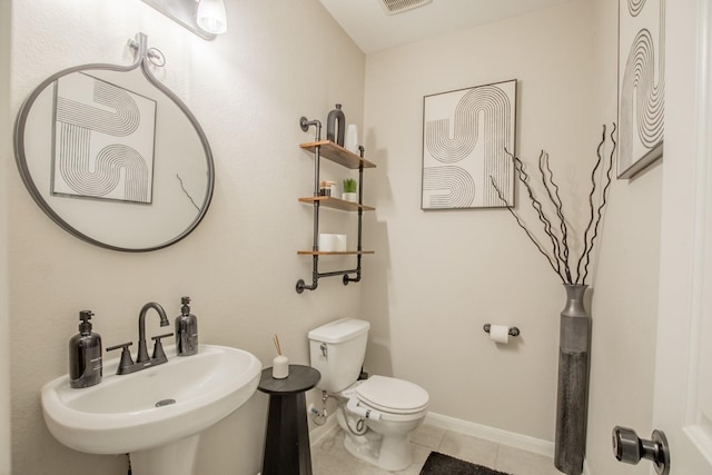 bathroom with a sink, toilet, tile patterned floors, baseboards, and visible vents