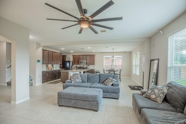 living room featuring a ceiling fan, light tile patterned flooring, and a healthy amount of sunlight