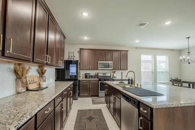 kitchen with appliances with stainless steel finishes, a sink, a chandelier, backsplash, and visible vents