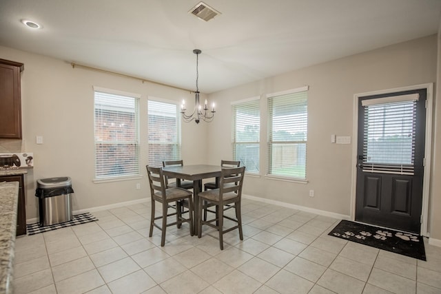 dining space with visible vents, plenty of natural light, light tile patterned floors, and a notable chandelier