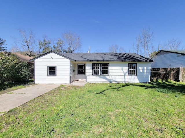 ranch-style home with fence, driveway, and a front lawn