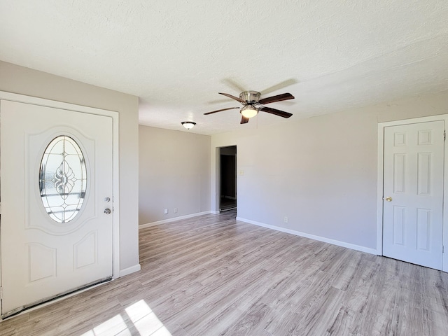 entryway with baseboards, a textured ceiling, ceiling fan, and light wood-style flooring