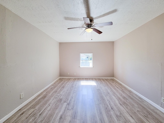 unfurnished room with baseboards, a ceiling fan, and light wood-style flooring