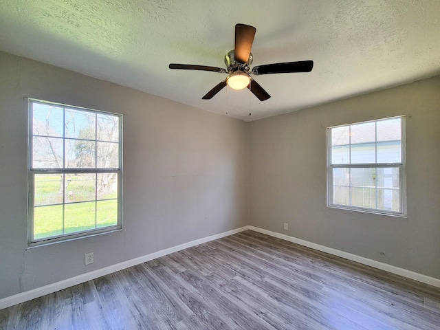 unfurnished room featuring a textured ceiling, baseboards, ceiling fan, and wood finished floors