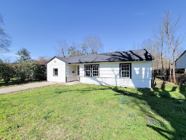 back of house with fence and a yard