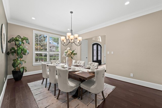 dining area featuring a notable chandelier, arched walkways, baseboards, wood finished floors, and ornamental molding