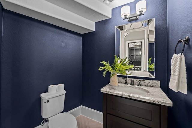 bathroom featuring vanity, baseboards, visible vents, and toilet