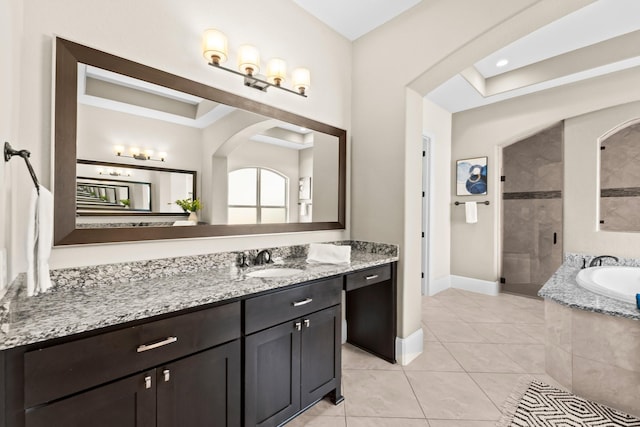 bathroom featuring vanity, baseboards, tiled shower, tile patterned floors, and a bath