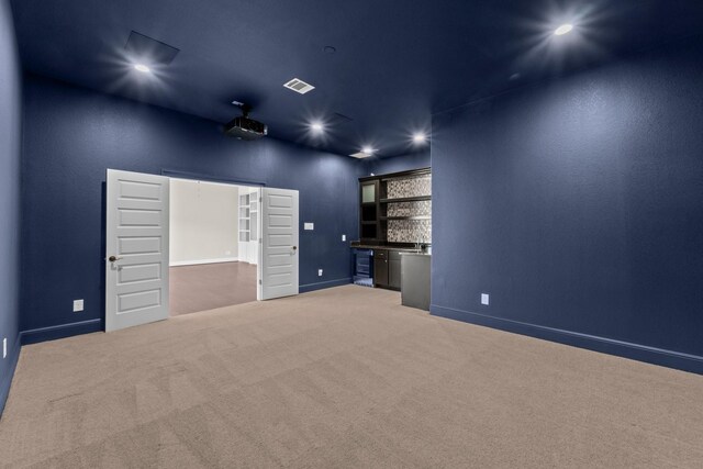 unfurnished room featuring visible vents, light carpet, baseboards, recessed lighting, and bar area