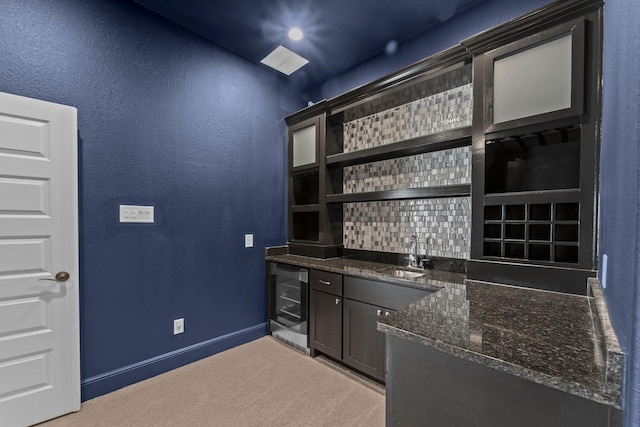 bar featuring a textured wall, wine cooler, light colored carpet, a sink, and wet bar