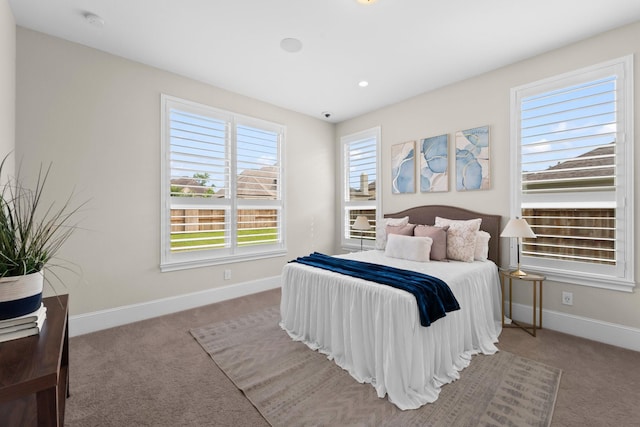 bedroom featuring light colored carpet and baseboards